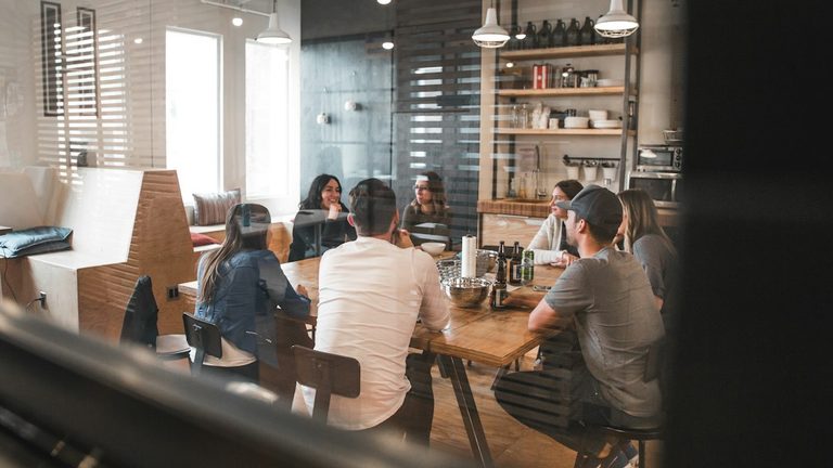 Colleagues sitting together around a table in a bright office